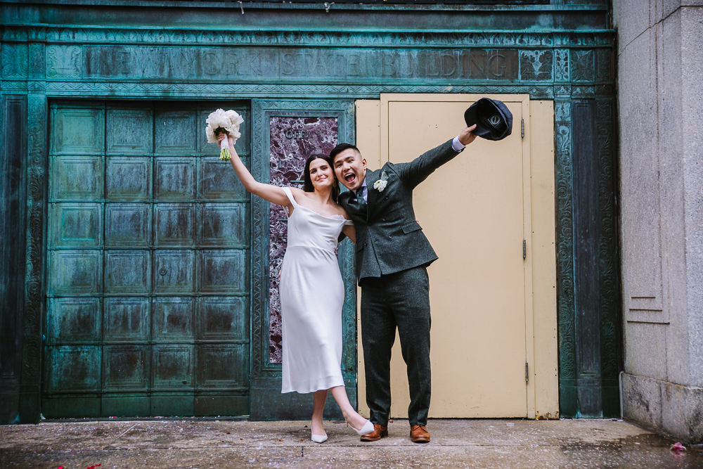 Newlyweds celebrating their marriage outside NYC City Hall, posing joyfully after their intimate city wedding.